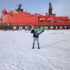 Nordpolen: Opdagelsesrejsende Inge Solheim holder et flag, der repræsenterer mål 13: Klimaindsats.