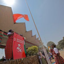 Kenyanske børn hejser flaget, der repræsenterer mål 14: Industri, Innovation og Infrastruktur. Foto: James Ochweri